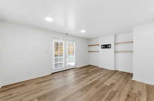 Spare room featuring light wood-style flooring and french doors