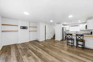 Living area featuring light wood-style flooring and recessed lighting