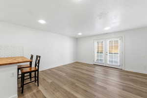 Unfurnished dining area featuring french doors, light wood-style flooring, and recessed lighting