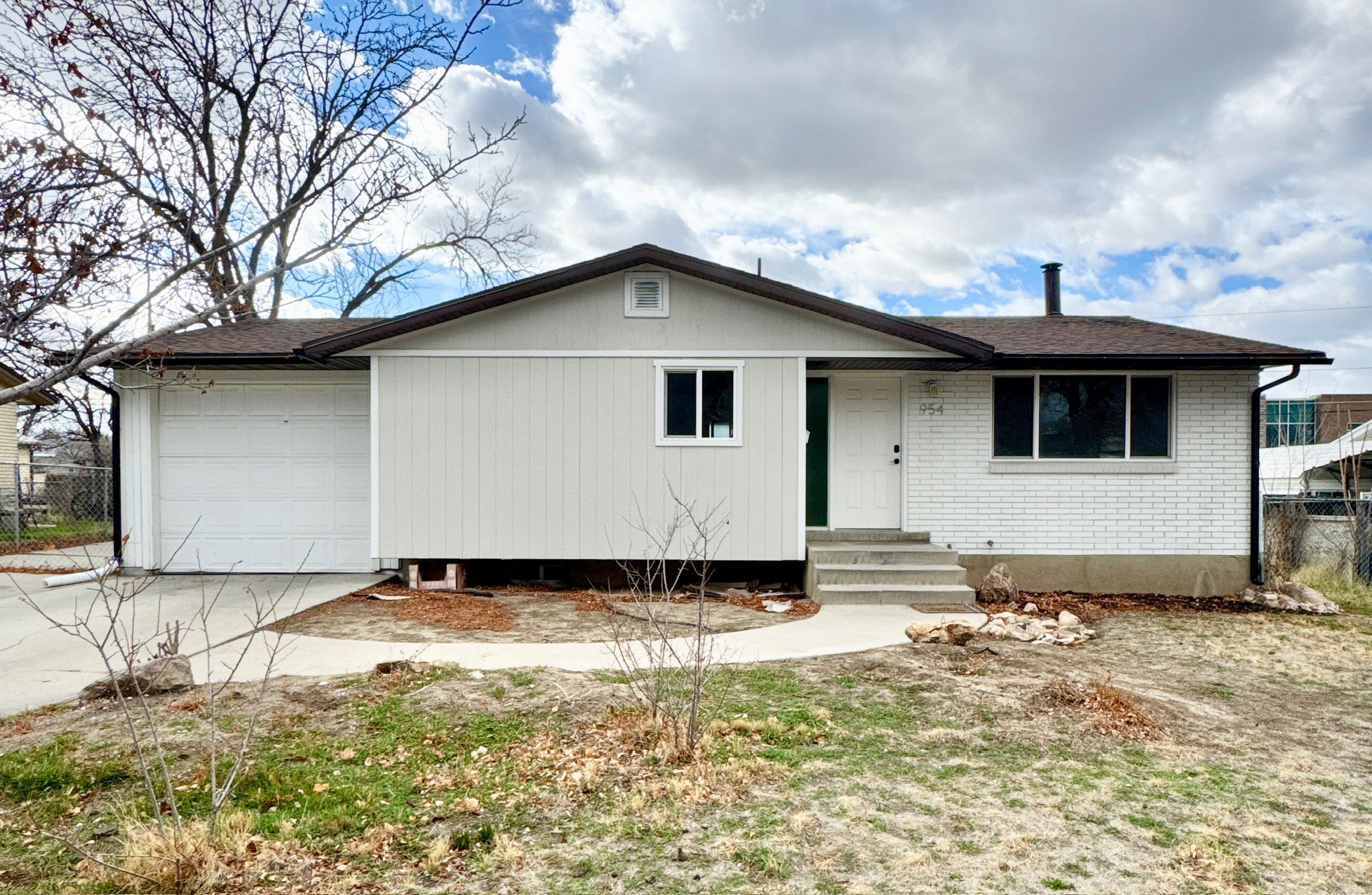 Ranch-style house with a garage, driveway, brick siding, and a shingled roof