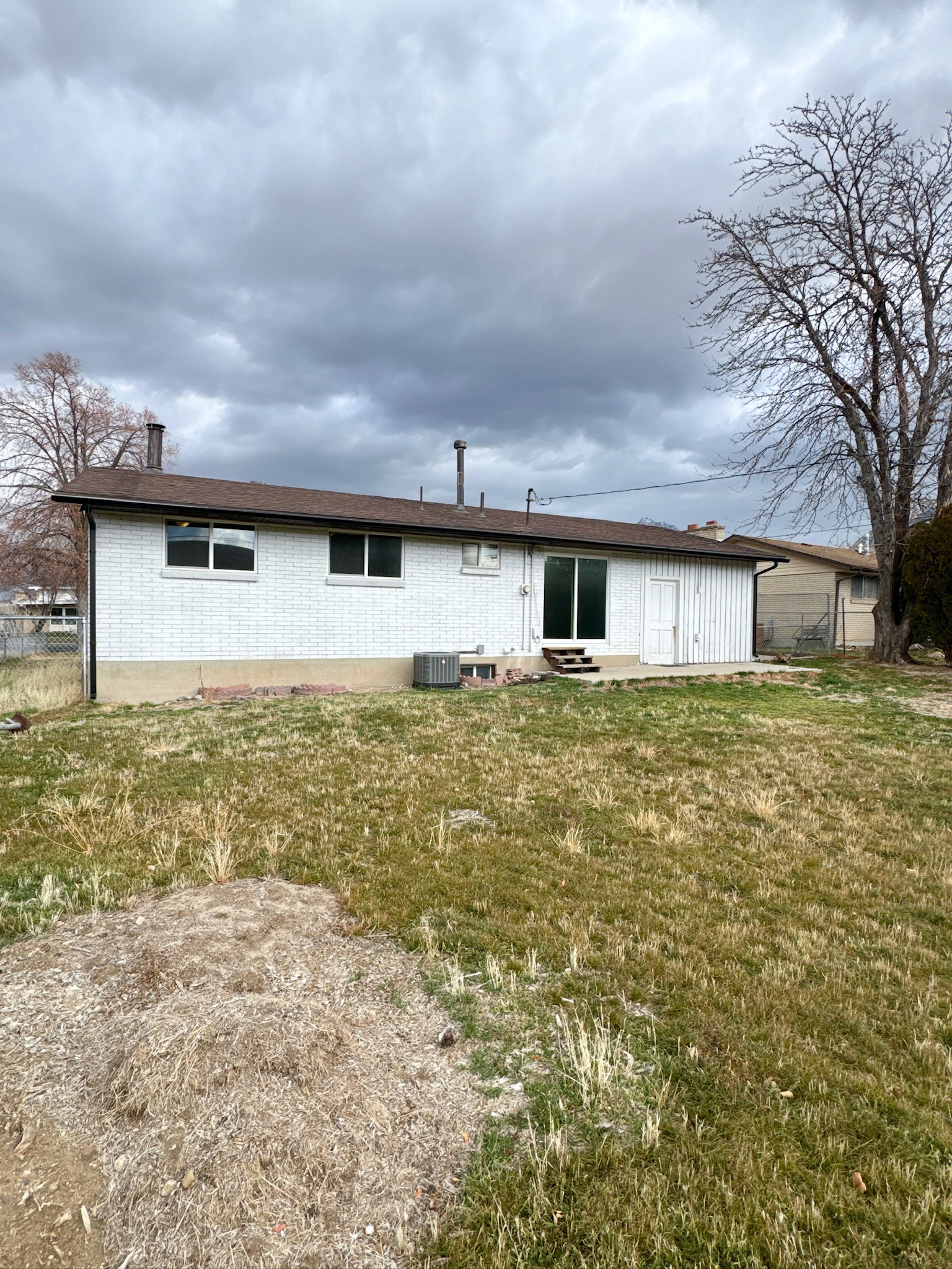 Rear view of house with brick siding and entry steps