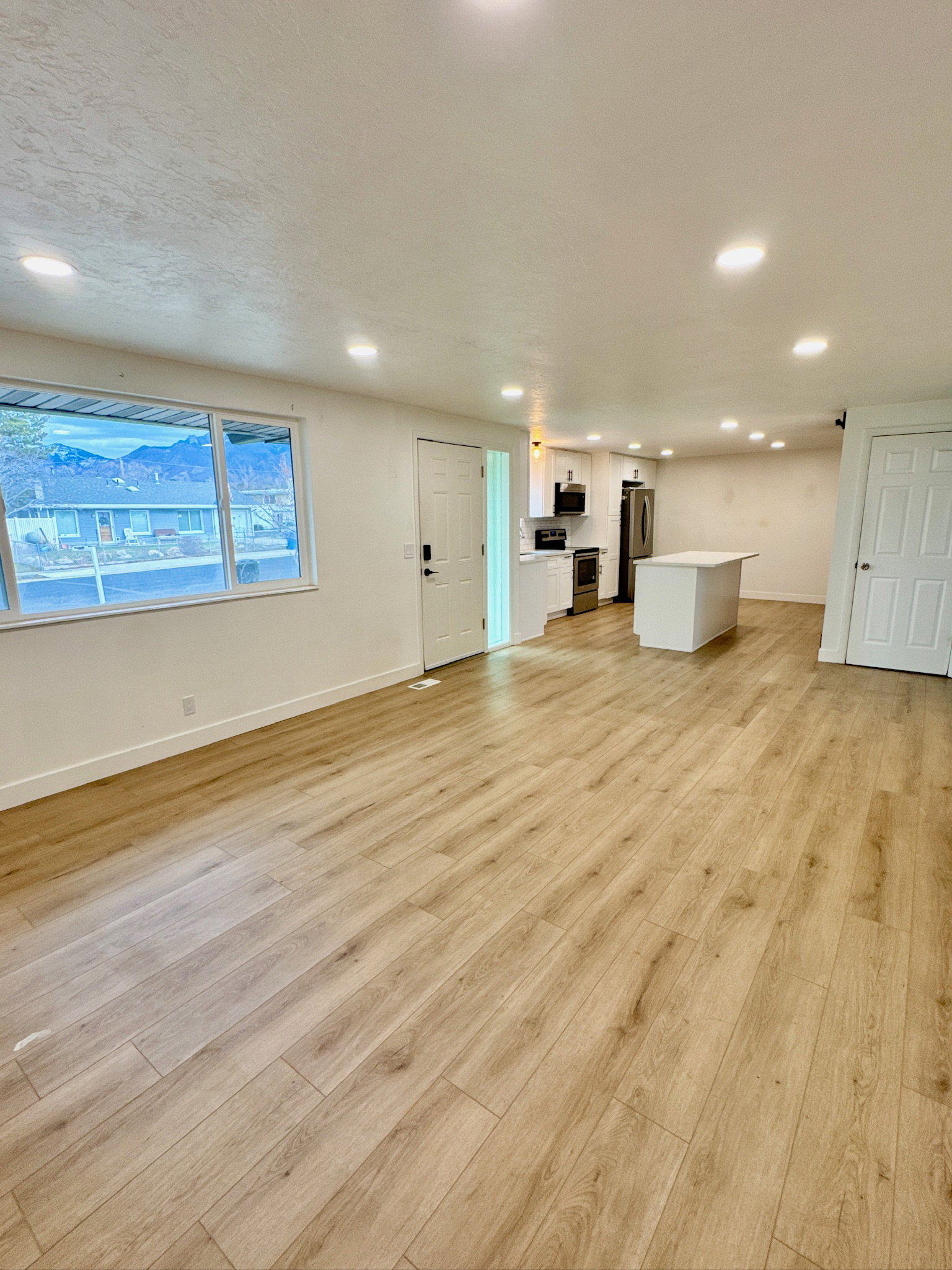 Unfurnished living room featuring light wood-style floors, recessed lighting, and a textured ceiling