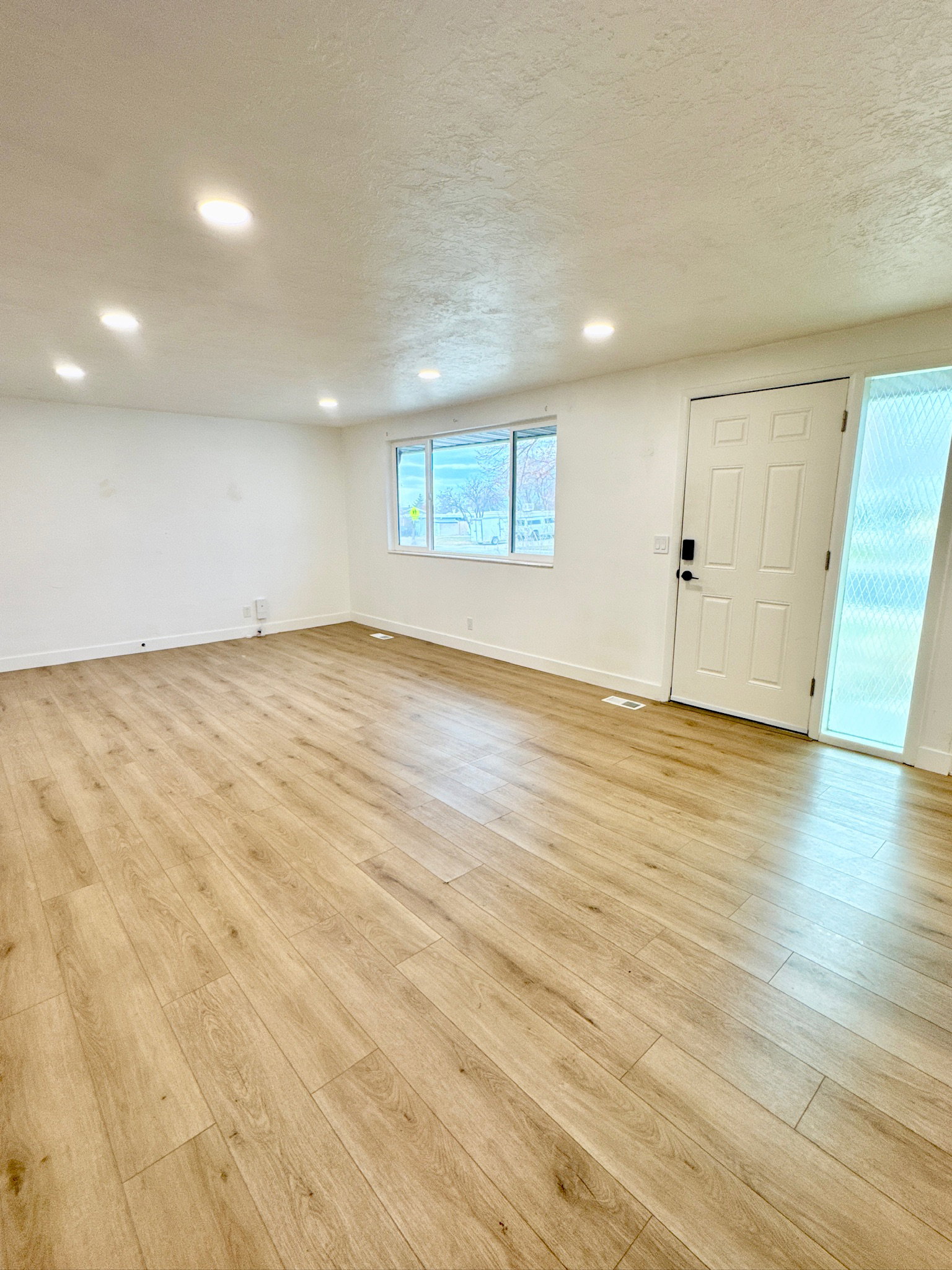 Foyer entrance featuring a textured ceiling, light wood finished floors, and recessed lighting