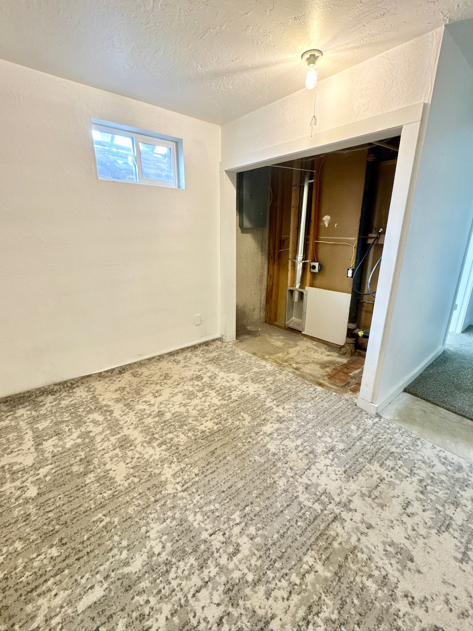 Below grade area featuring a textured ceiling and baseboards