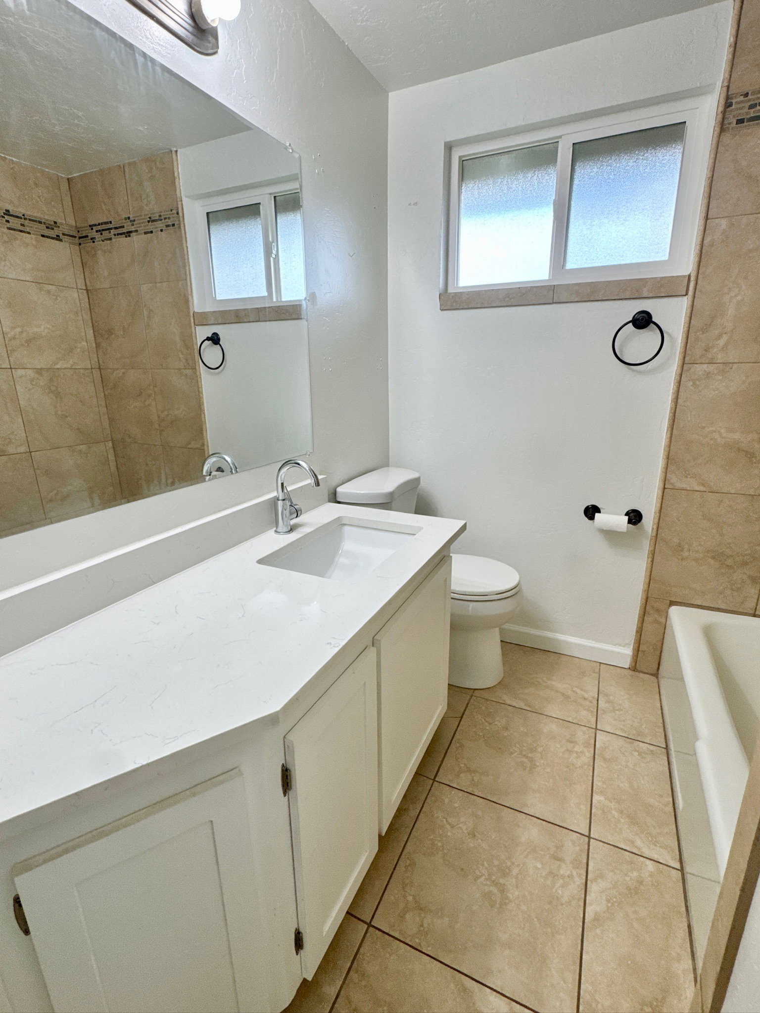 Bathroom with vanity, light tile patterned flooring, and bathtub / shower combination