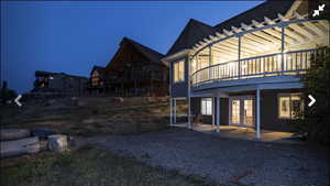 Yard at twilight featuring a patio area, a deck, and french doors