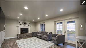 Living area with recessed lighting, wood finished floors, a fireplace, and french doors
