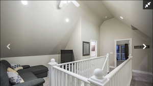 Hallway featuring lofted ceiling and an upstairs landing