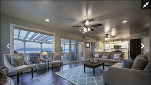 Living room with recessed lighting, dark wood-style flooring, a mountain view, and a ceiling fan