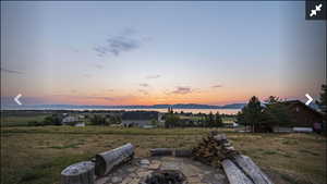 Yard at dusk featuring an outdoor fire pit, a patio area, and a mountain view