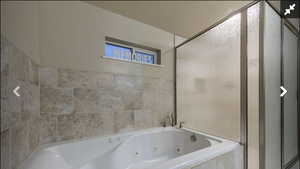 Full bath with a whirlpool tub and a stall shower