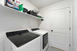 Laundry room featuring independent washer and dryer and light tile patterned floors