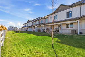 Rear view of property with board and batten siding, stone siding, a patio, and a residential view
