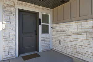 View of exterior entry featuring stone siding