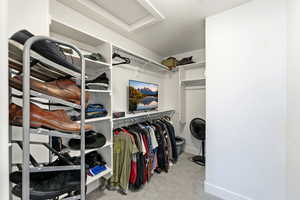 Walk in closet with attic access and light carpet