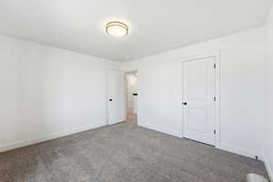 Unfurnished bedroom with baseboards and carpet