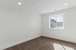 Spare room featuring dark colored carpet and recessed lighting