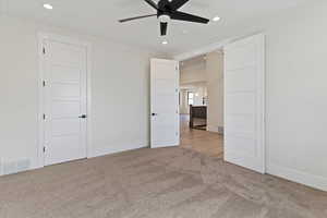 Unfurnished bedroom featuring light colored carpet, recessed lighting, and ceiling fan