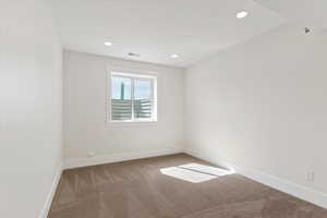 Spare room featuring light colored carpet and recessed lighting