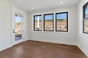 Spare room with wood finished floors and recessed lighting