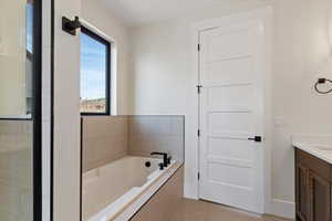 Bathroom with vanity and a bath