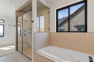 Full bathroom with a stall shower, a garden tub, light tile patterned flooring, and recessed lighting