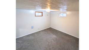 Unfurnished bedroom with light colored carpet, a closet, and a textured ceiling