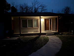 Night view  of exterior entry with a  covered porch and chimney
