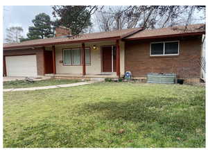 Ranch-style house featuring an attached garage, covered porch, a front yard, brick siding, and a shingled roof