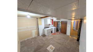 Laundry room with light colored carpet, white cabinets, utility sink, washing machine and clothes dryer