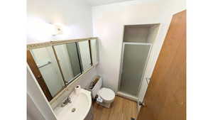 Primary bathroom featuring a stall shower and wood finished floors