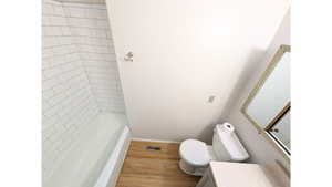 Full bathroom featuring vanity, wood finished floors, and shower/tub combination