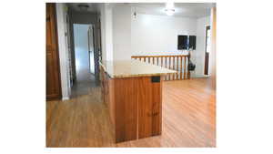 Kitchen featuring light wood-style floors, wood finish cabinetry, a center island with granite countertop