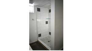 Bathroom featuring a tile shower stall