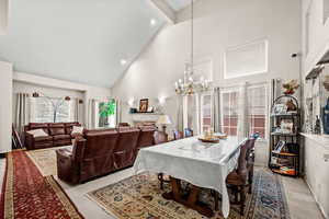 Dining room featuring light colored carpet, suspended lighting, and vaulted ceiling