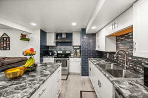 Kitchen with electric range, white cabinets, open floor plan, dark stone countertops, and recessed lighting