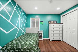 Bedroom featuring dark wood-style flooring and a closet