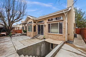 Back of house with a patio, brick siding, and entry steps