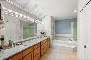 Full bath featuring a closet, double vanity, a garden tub, recessed lighting, and a stall shower
