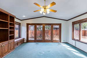 Unfurnished living room with carpet floors, ceiling fan, and crown molding