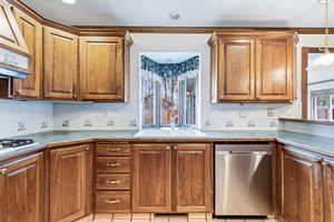Kitchen with decorative backsplash, stainless steel appliances, wood finish cabinetry, and light tile patterned floors