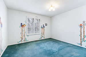 Spare room featuring carpet and a textured ceiling