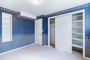 Unfurnished bedroom with light colored carpet and a closet