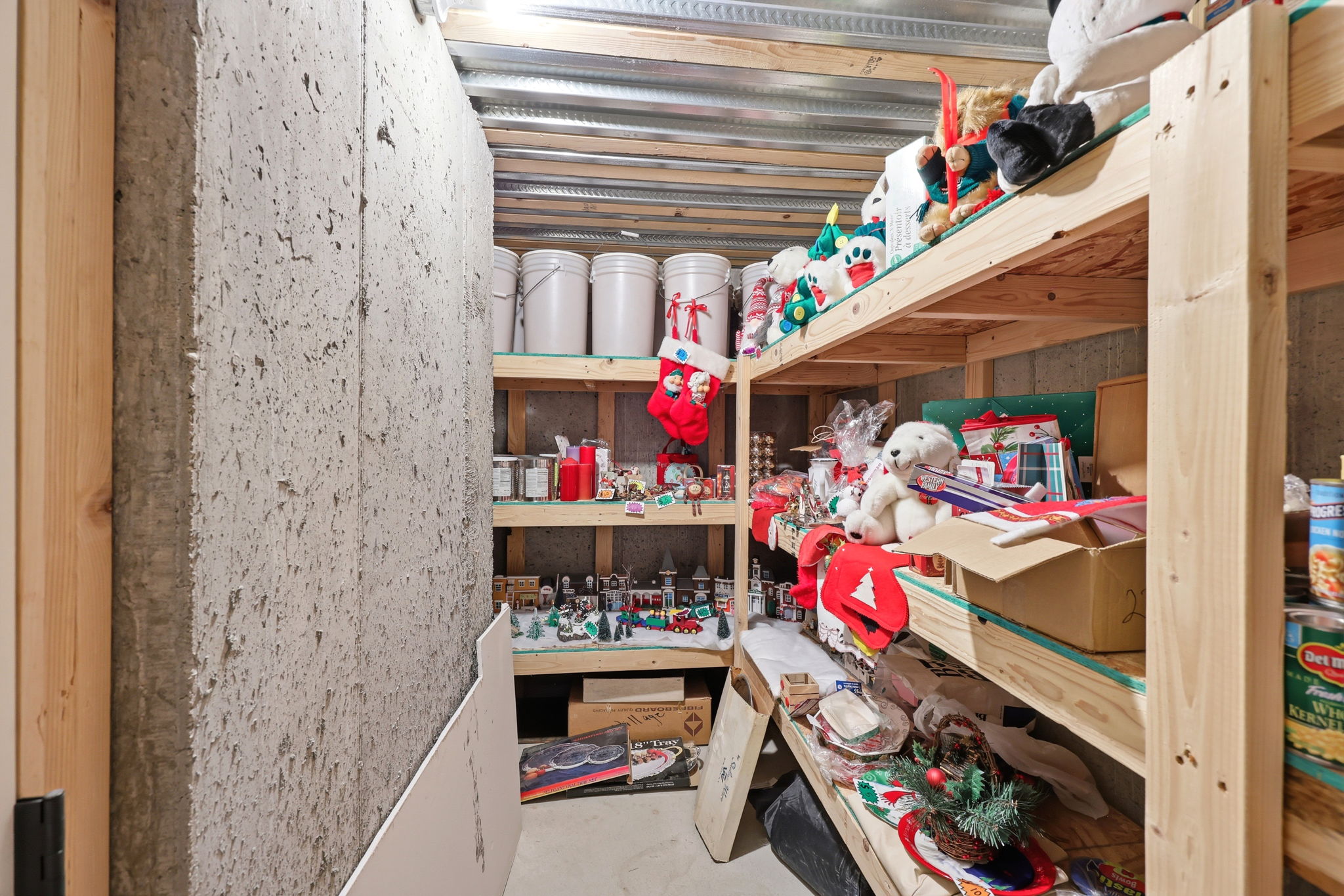 Utility area featuring concrete walls and built-in wood shelving