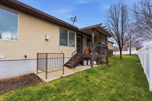 Rear view of house with a patio, a deck, and stucco siding