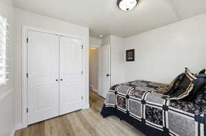 Bedroom with light wood-style flooring and a closet
