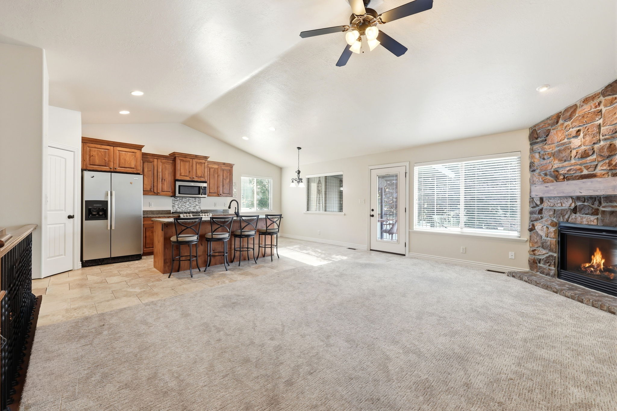 Spacious open-concept living area featuring vaulted ceilings and recessed lighting