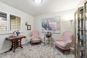 Living area featuring light colored carpet and baseboards