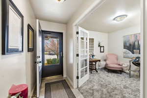 Entryway featuring carpet and baseboards
