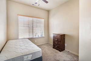 Bedroom featuring light colored carpet and a ceiling fan